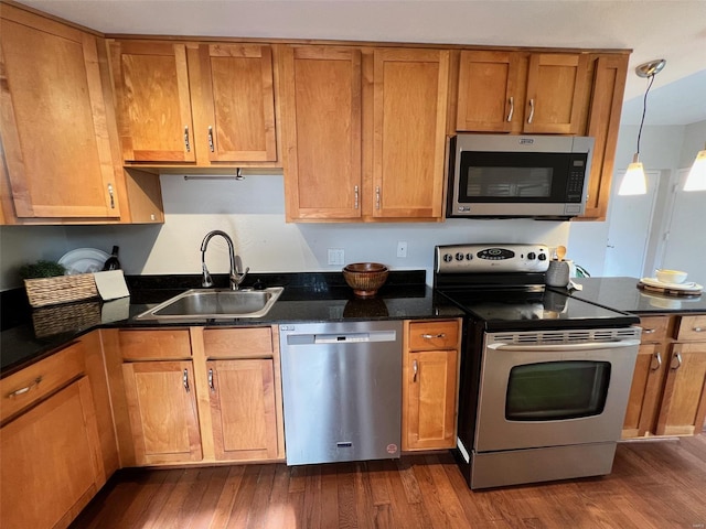 kitchen featuring pendant lighting, dark hardwood / wood-style flooring, sink, and appliances with stainless steel finishes