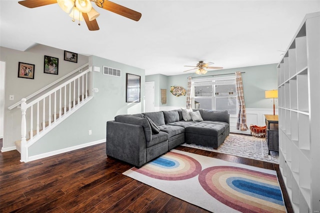 living room featuring ceiling fan and dark hardwood / wood-style floors