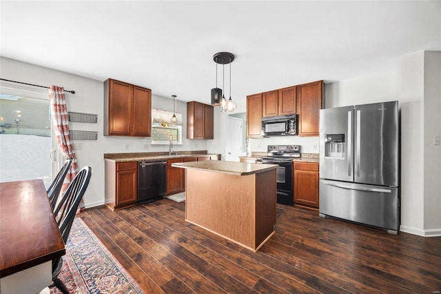 kitchen with a kitchen island, dark wood-type flooring, pendant lighting, and appliances with stainless steel finishes