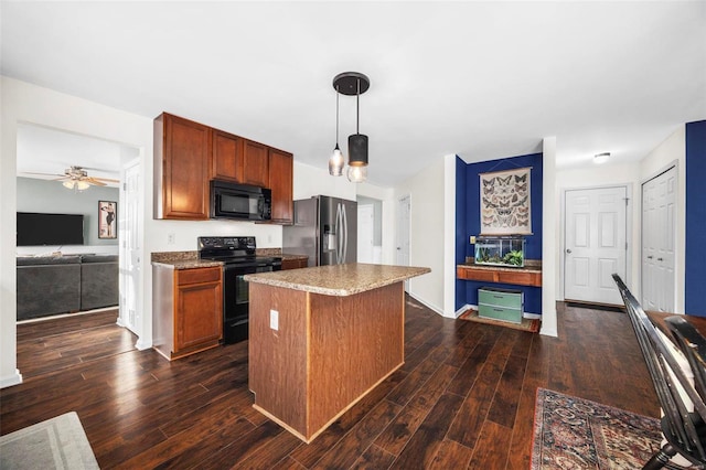 kitchen with ceiling fan, hanging light fixtures, a kitchen island, black appliances, and dark wood-type flooring