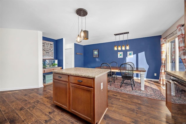 kitchen with a kitchen island, dark hardwood / wood-style flooring, and pendant lighting