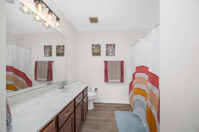 bathroom featuring toilet, vanity, and hardwood / wood-style floors