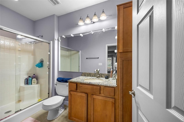 bathroom with vanity, toilet, and an enclosed shower