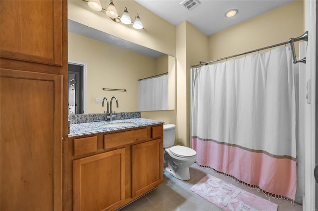 bathroom with toilet, vanity, walk in shower, and tile patterned flooring