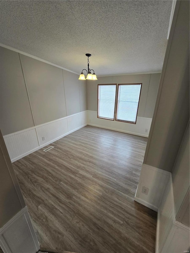 empty room with dark hardwood / wood-style floors and a notable chandelier