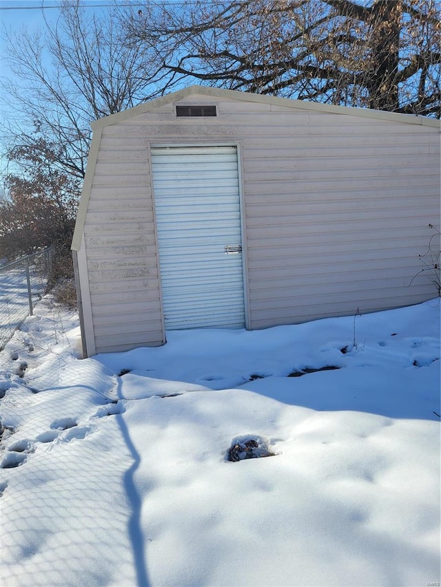 snow covered structure with a garage