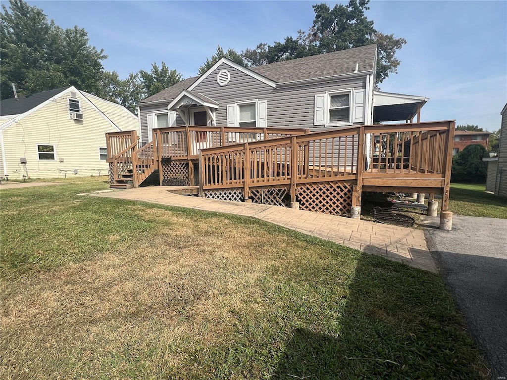 rear view of property featuring a lawn and a deck