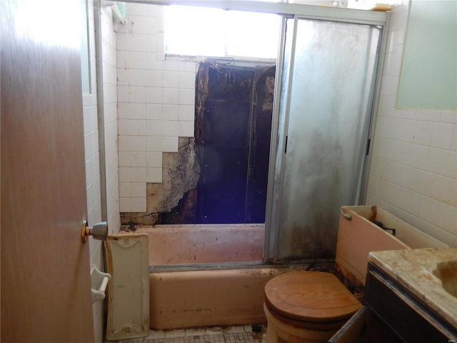 full bathroom featuring vanity, bath / shower combo with glass door, and toilet