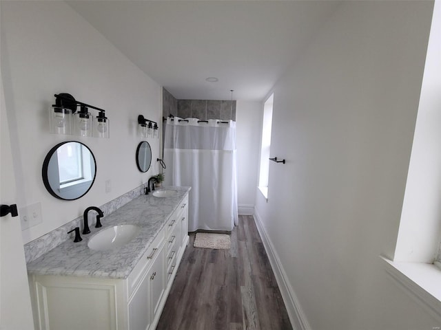 bathroom featuring hardwood / wood-style floors, vanity, a healthy amount of sunlight, and walk in shower