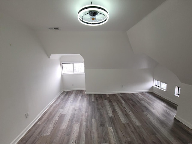 additional living space with dark hardwood / wood-style floors and vaulted ceiling