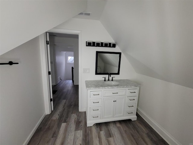 bathroom featuring vanity, lofted ceiling, and hardwood / wood-style flooring