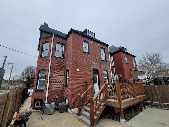 back of house with central AC, a deck, and a patio area