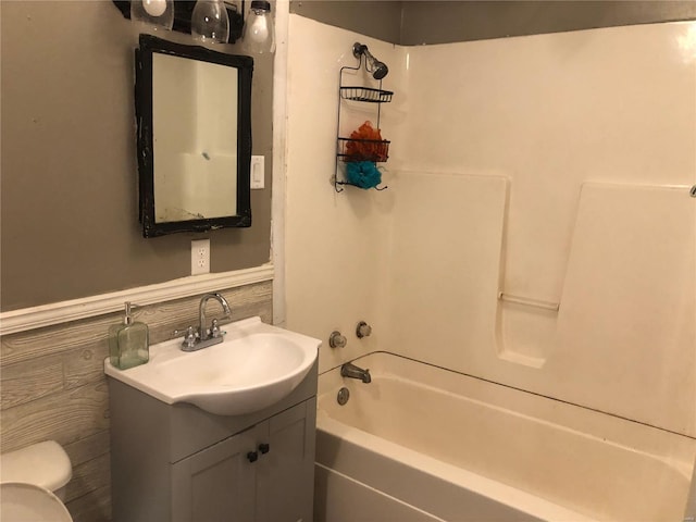 full bathroom featuring toilet, vanity, and  shower combination