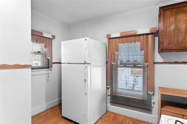 kitchen featuring light wood-type flooring and white fridge