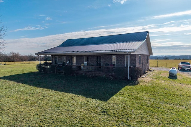 rear view of property featuring a yard and a porch