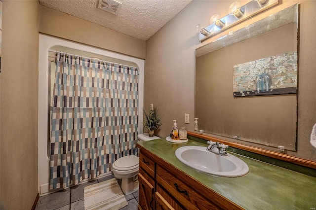 bathroom featuring tile patterned floors, vanity, toilet, and a textured ceiling