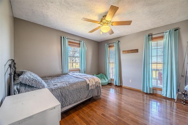 bedroom featuring ceiling fan, a textured ceiling, and hardwood / wood-style flooring