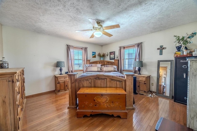 bedroom featuring multiple windows, ceiling fan, light hardwood / wood-style floors, and a textured ceiling