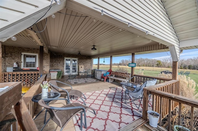 view of patio / terrace with a wooden deck, french doors, and a rural view