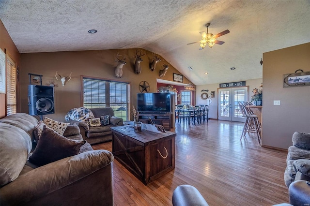 living room with french doors, a textured ceiling, hardwood / wood-style flooring, and ceiling fan