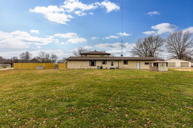 rear view of house featuring a storage unit and a lawn