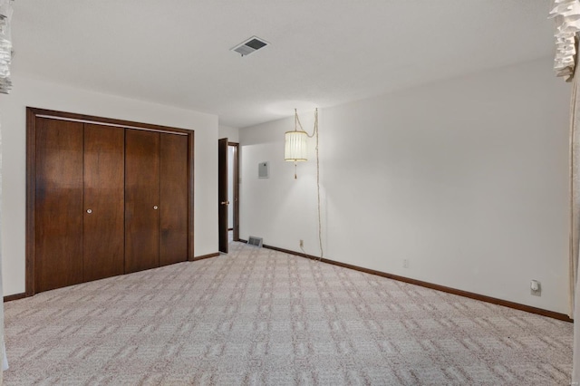 unfurnished bedroom with a closet and light carpet