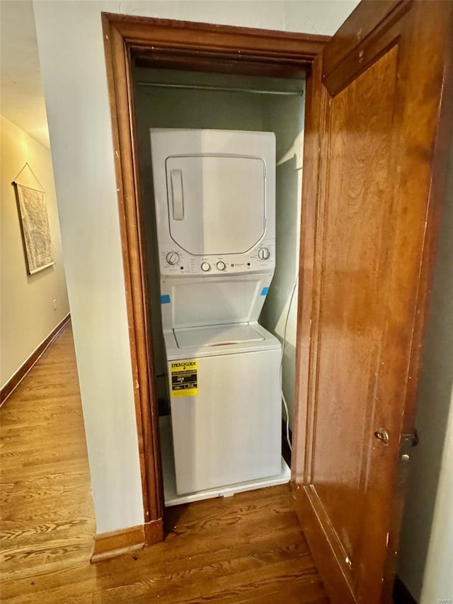 washroom featuring stacked washing maching and dryer and hardwood / wood-style flooring