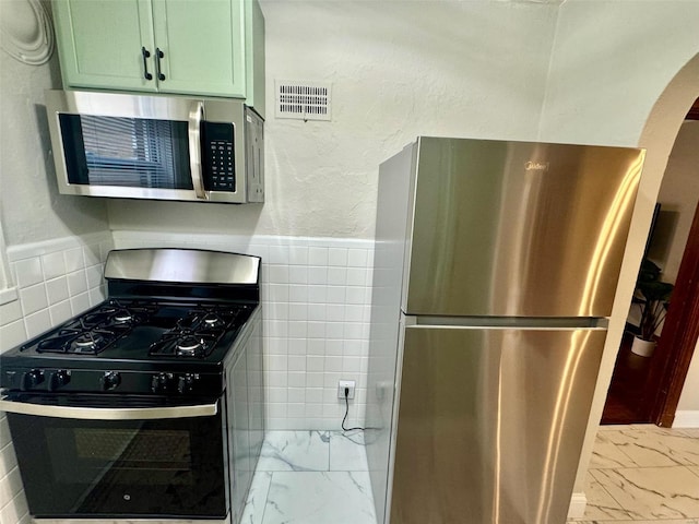 kitchen featuring stainless steel appliances and green cabinetry