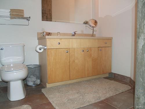 bathroom featuring toilet, vanity, and tile patterned flooring