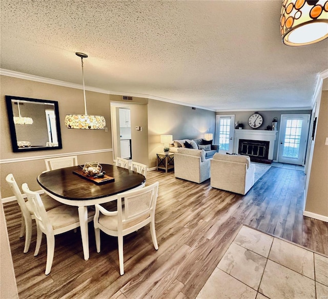 dining area featuring a textured ceiling, crown molding, and hardwood / wood-style flooring