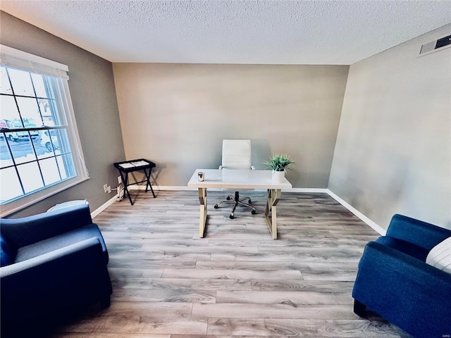 office featuring a textured ceiling and light hardwood / wood-style flooring