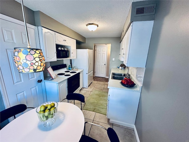 kitchen featuring white appliances, a textured ceiling, light tile patterned floors, white cabinetry, and sink