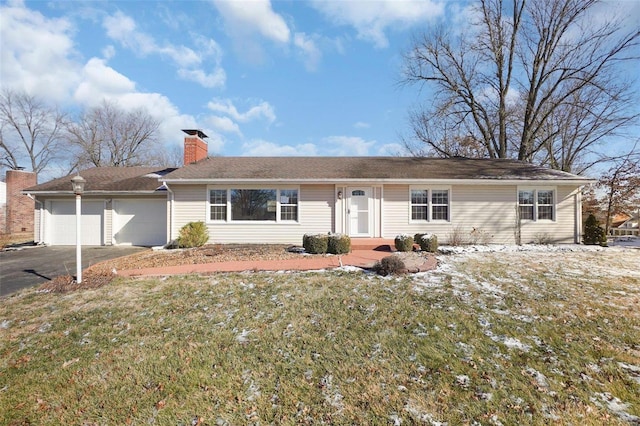 ranch-style home with a garage and a front lawn