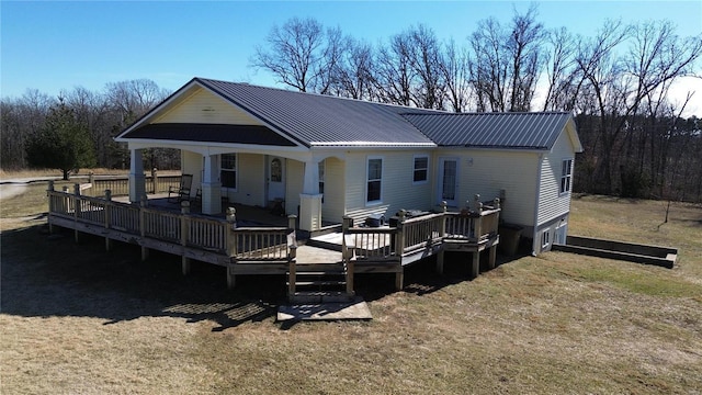 rear view of property featuring a yard and a deck