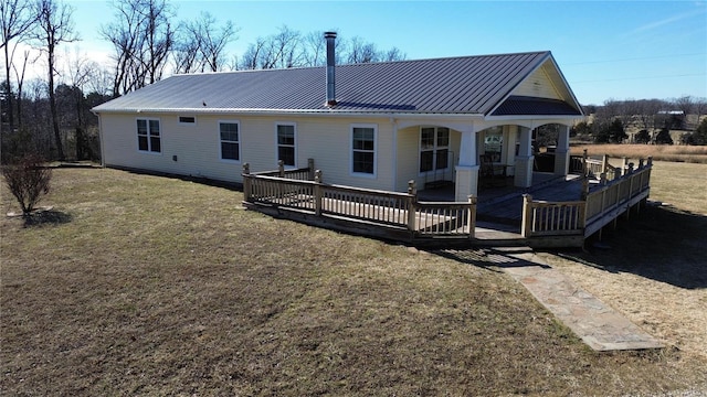 rear view of house featuring a wooden deck and a lawn