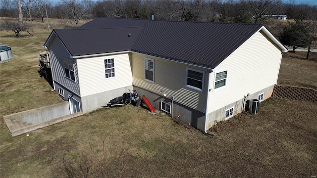 rear view of house featuring a yard and central AC