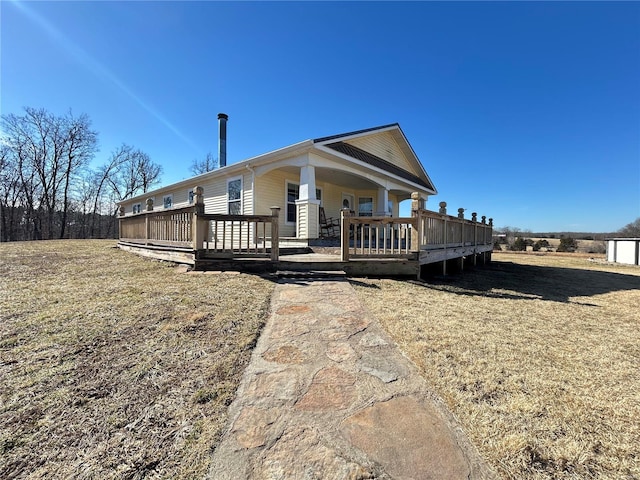 view of front of house featuring a front lawn and a deck