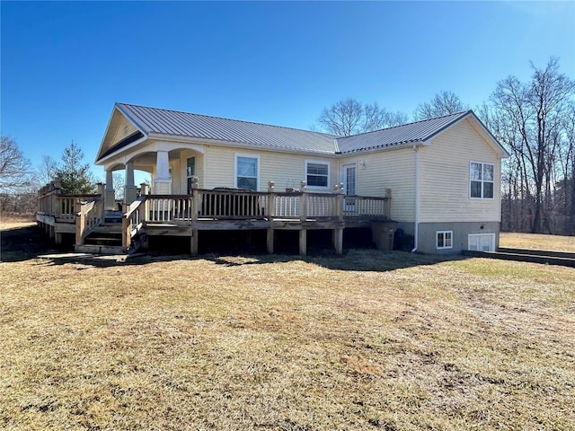 rear view of property with a wooden deck and a lawn