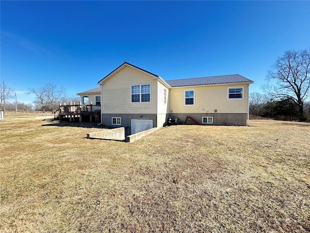 rear view of house featuring a wooden deck and a yard