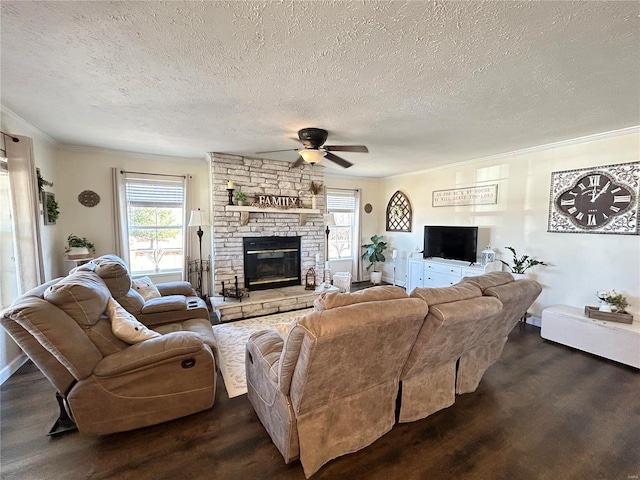 living room with a fireplace, crown molding, dark wood-type flooring, and ceiling fan