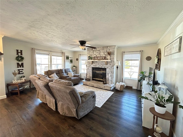 living room with ceiling fan, ornamental molding, a textured ceiling, dark hardwood / wood-style flooring, and a stone fireplace