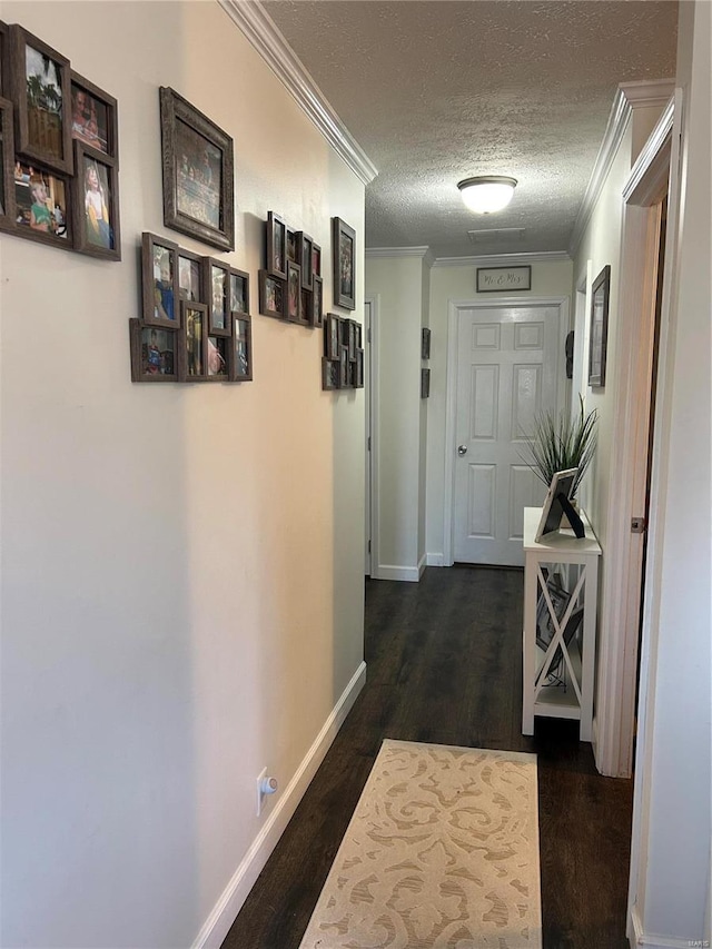 hall featuring crown molding, dark hardwood / wood-style floors, and a textured ceiling