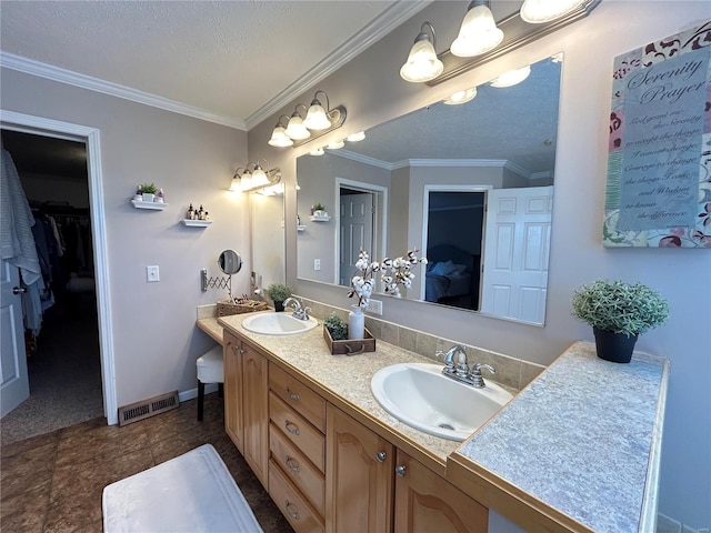 bathroom featuring vanity, ornamental molding, and a textured ceiling