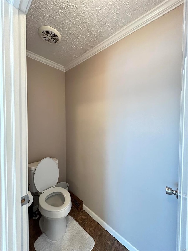 bathroom with crown molding, toilet, and a textured ceiling