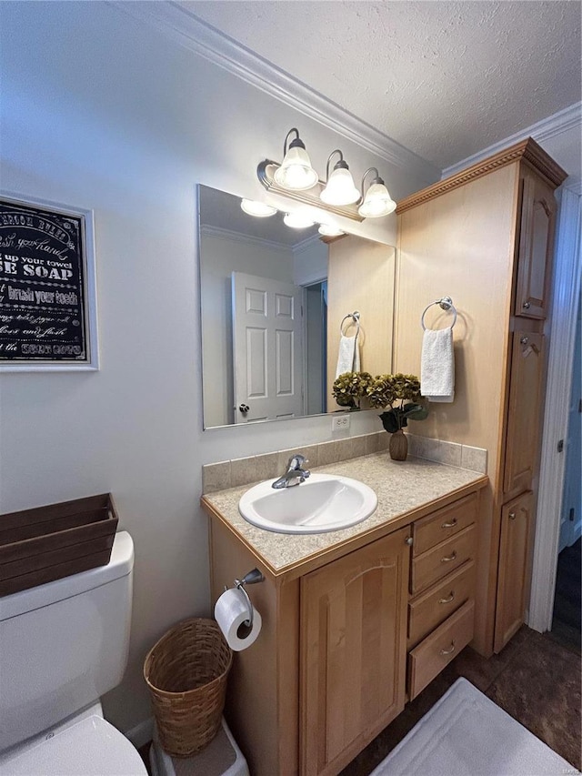 bathroom with vanity, crown molding, toilet, and a textured ceiling