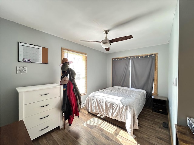 bedroom with dark hardwood / wood-style flooring and ceiling fan