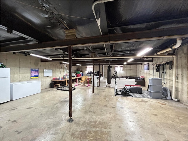 basement featuring white fridge and refrigerator