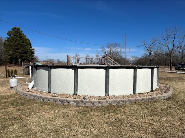 view of outdoor structure featuring a lawn and a covered pool