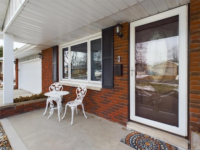 doorway to property with covered porch and a garage