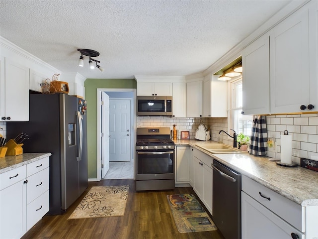 kitchen with stainless steel appliances, dark hardwood / wood-style flooring, white cabinetry, and sink